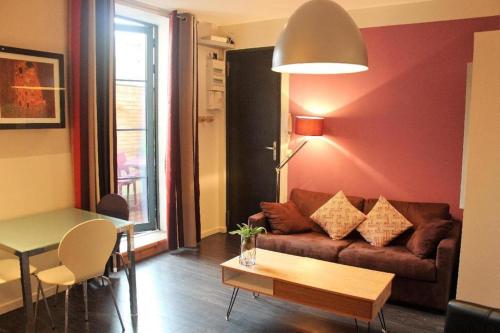 - un salon avec un canapé et une table dans l'établissement Burdigala Homes - Les Apparts de la Course, à Bordeaux