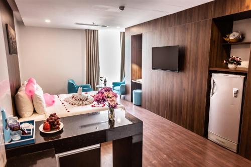 a hotel room with a bed and a television at Gold Central Hotel by Haviland in Da Nang