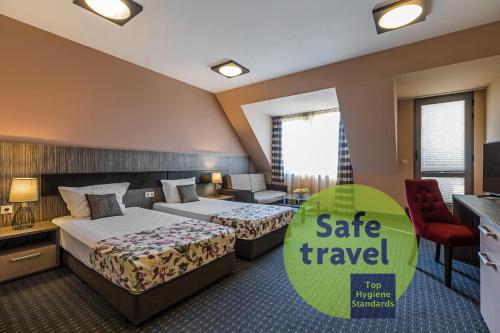 a hotel room with two beds and a tv at Plaza Hotel Plovdiv - Free Parking in Plovdiv