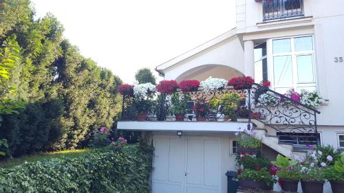biały dom z kwiatami na balkonie w obiekcie Vila Sentić w mieście Vranje