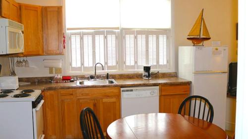 a kitchen with a table and a sink and a refrigerator at Camden Riverhouse Hotel and Inn in Camden
