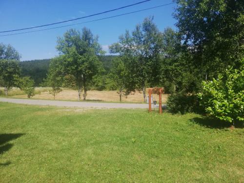 a grassy field with a road in the distance at The House of Dunja in Rakovica