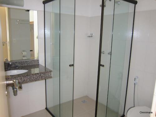 a bathroom with a glass shower and a sink at Pousada Omnimare in Ubatuba