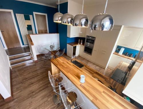 a kitchen with a counter and chairs in a room at Pineapple Apartments in Aberdeen