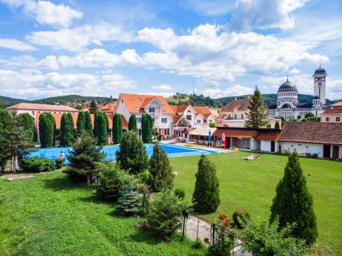een resort met een grote tuin met een zwembad bij Pension Aquaris in Sighişoara