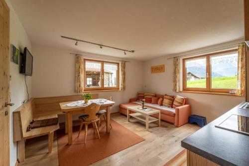 a living room with a table and a couch at Forsthaus Schoppernau in Schoppernau
