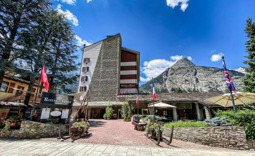 un edificio alberghiero con una montagna sullo sfondo di Grand Hotel Royal E Golf a Courmayeur