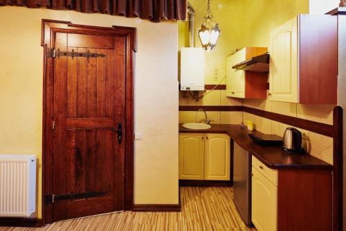 a kitchen with a wooden door and a sink at Квартира подобово на Площі Ринок 39 in Lviv