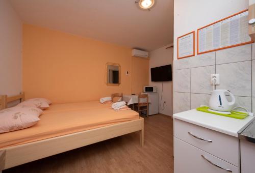 Un pequeño dormitorio con una cama y una cocina. en Studios Lavender, en Split