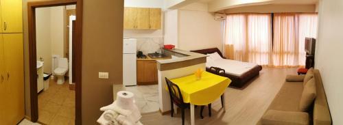 a kitchen and a living room with a yellow table at Vila Zuzette in Constanţa