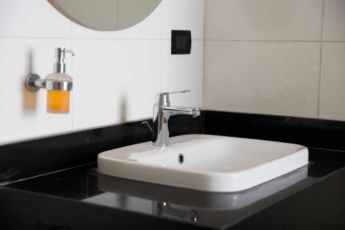 a white sink on a black counter in a bathroom at Redcon Suites in Hurghada