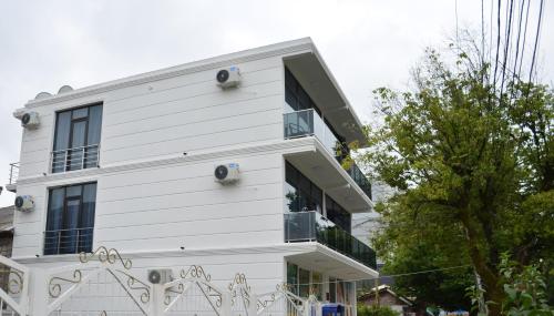 a white building with graffiti on the side of it at White Hotel in K'obulet'i