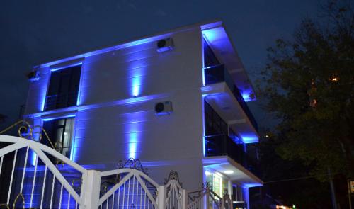 a building with blue lights on it at night at White Hotel in K'obulet'i