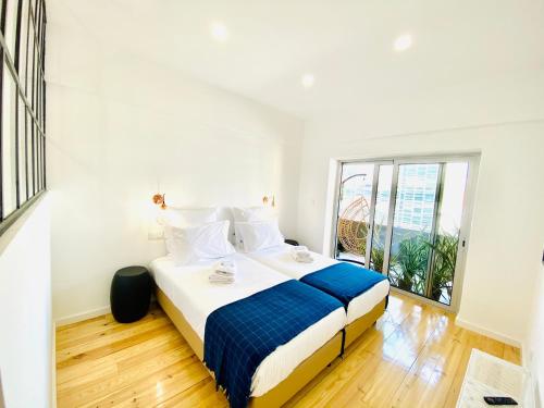 a bedroom with a bed and a large window at The Postcard Avenue in Lisbon