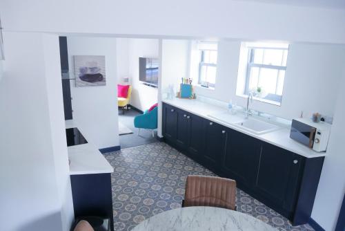 cocina con fregadero y encimera en New street Luxury town house in the centre of Holt with free PARKING for one car, en Holt