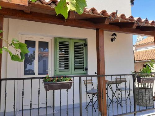 a balcony of a house with a green window and chairs at Casa Nonna Tereza in Premantura