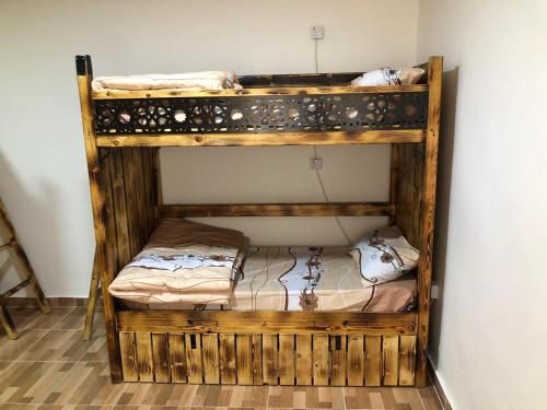 a wooden bunk bed in a small room at Hakaia Community in Aqaba