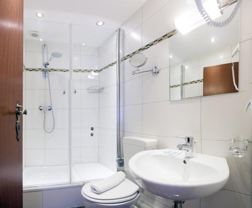 La salle de bains est pourvue d'un lavabo, d'une douche et de toilettes. dans l'établissement Wali's Hotel, à Bielefeld