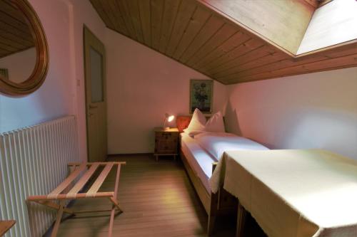 a bedroom with two beds and a table and a chair at Haus Tusculum in Solda