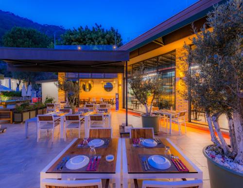 a dining room with tables and chairs and a patio at Morina Deluxe Hotel in Oludeniz