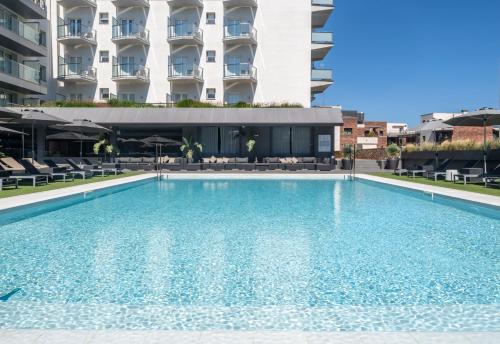 a large swimming pool in front of a building at Astari in Tarragona