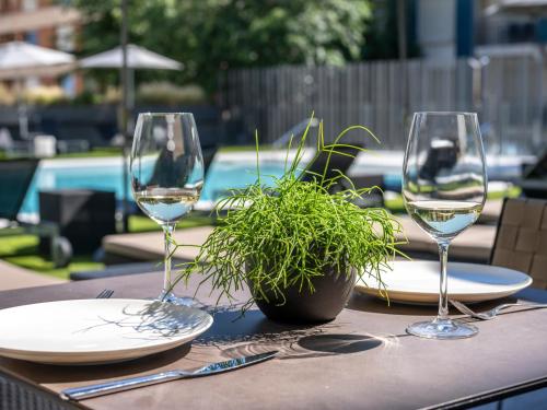 a table with two wine glasses and a potted plant at Astari in Tarragona