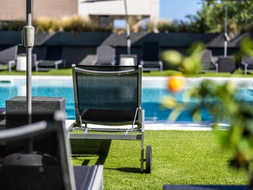 a chair sitting in front of a swimming pool at Astari in Tarragona