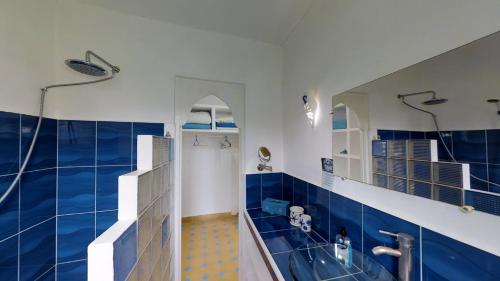 a blue and white bathroom with a shower and a tub at Villa Daba in Ghazoua
