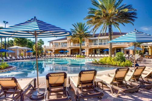 a pool at a resort with chairs and umbrellas at FantasyWorld Resort in Kissimmee