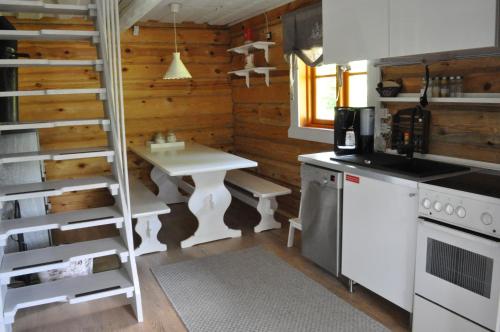 una cocina con una mesa blanca y una escalera en Villa Verde, en Kihelkonna