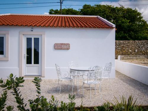 a table and chairs in front of a white building at Quinta Pedra Firme in Sintra