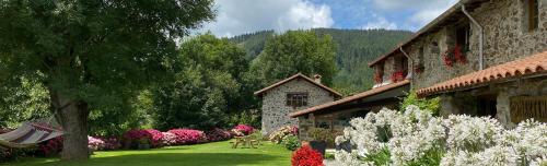 un jardín con flores rosas junto a un edificio en Casa Rural Martiamuno Landetxea en Zumárraga