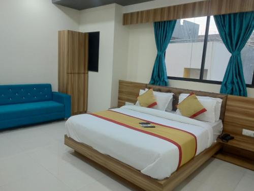 1 dormitorio con 1 cama grande y 1 sofá azul en hotel restandride, en Anand