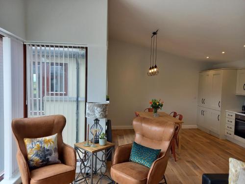 a living room with two chairs and a table at Murrisk Apartments - Self Catering in Westport