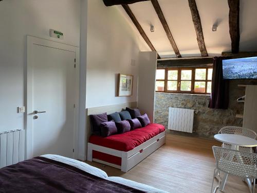 Un dormitorio con un sofá con almohadas moradas. en Casa Rural Martiamuno Landetxea en Zumárraga