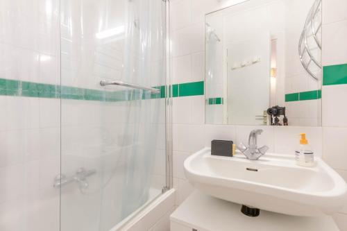 une salle de bain blanche avec un lavabo et une douche dans l'établissement Cimes 8, à Morzine