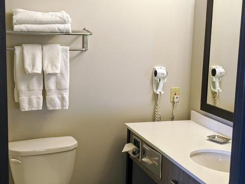 a bathroom with a toilet and a sink and a phone at Chateau Bedford Trademark Collection by Wyndham in Halifax