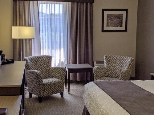 a hotel room with a bed and chairs and a desk at Chateau Bedford Trademark Collection by Wyndham in Halifax