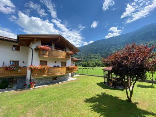 a house with two balconies and a grass yard at Villa Golf in Pinzolo