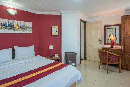 a bedroom with a bed and a desk and a computer at Hotel Raha Tower in Dar es Salaam