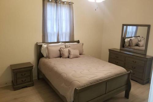ein Schlafzimmer mit einem Bett mit einem Spiegel und einer Kommode in der Unterkunft Villa 8 in Hammond