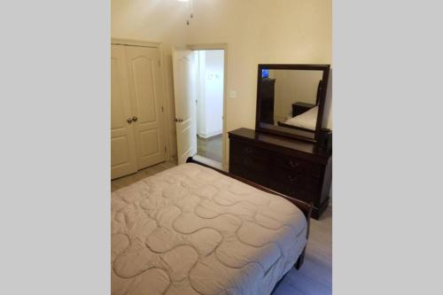 a bedroom with a bed with a dresser and a mirror at Villa 8 in Hammond