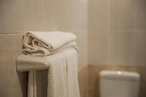 a bathroom with towels on a sink and a toilet at Redcon Suites in Hurghada