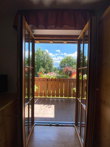 an open door to a balcony with a view of a yard at Villa Golf in Pinzolo