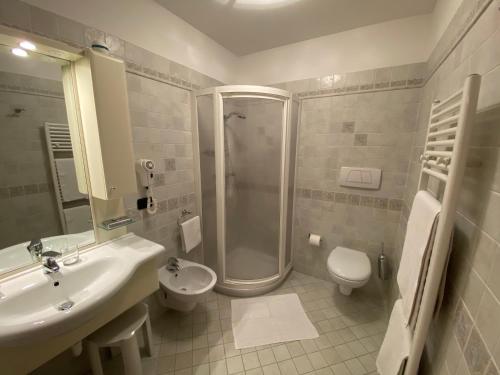 a bathroom with a sink and a shower and a toilet at Villa Golf in Pinzolo