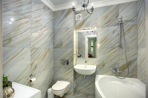 uma casa de banho com um lavatório, WC e um espelho. em Студия-Люкс с двумя спальнями на Соборной em Mykolaiv