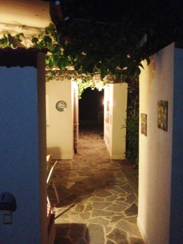 a hallway with a tunnel with ivy on the ceiling at Blumenhaus (Spiti Louloudia) in Paralía Sergoúlas