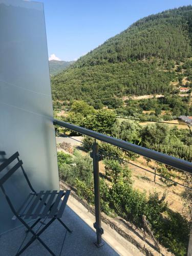 a chair on a balcony with a view of a mountain at Hotel da Vila in Manteigas