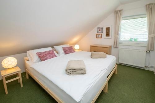 a large white bed in a room with a window at Apartmaji Rauter in Bohinj