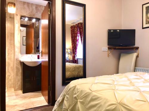 a bedroom with a sink and a bed and a mirror at Atlantic Guest House in Donegal